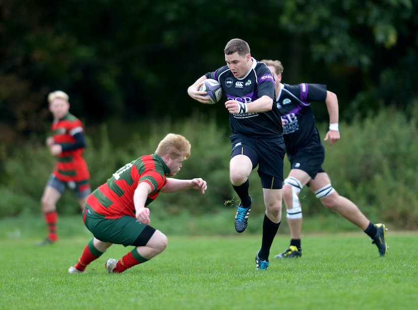 Rugby player sidestepping tackle