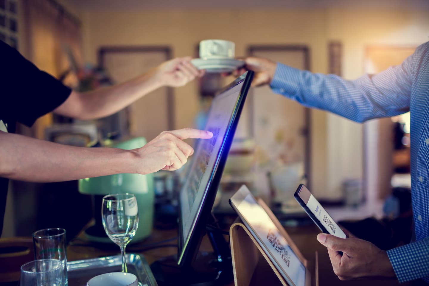 Man using a COVID track and trace QR code at a bar buying a coffee