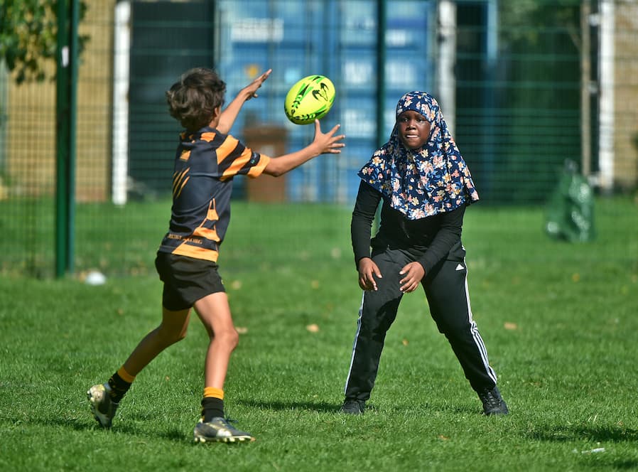 Girl in hijab playing rugby