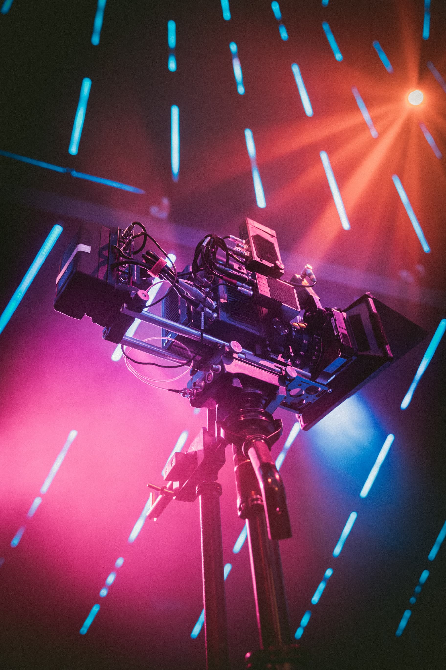 stylised shot of film camera with pink and orange lighting behind