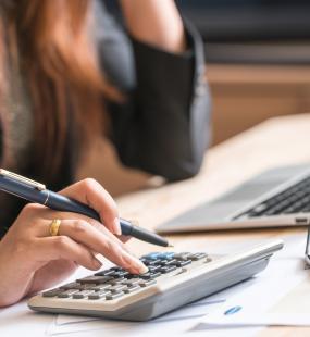 A female accountant uses a calculator at her desk