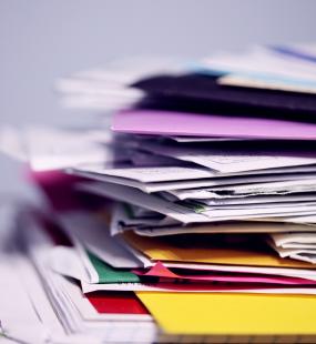 A stack of files sits on a desk