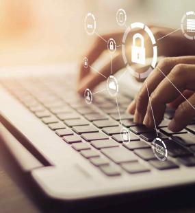 Fingers on a laptop with security icons