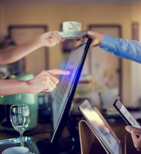 Man using a COVID track and trace QR code at a bar buying a coffee