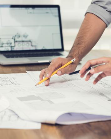 Two planning consultants discuss blueprints