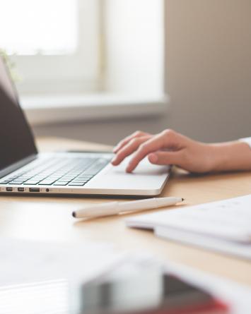 Woman working on a laptop A businesswoman in a white shirt sits at a desk using a laptop