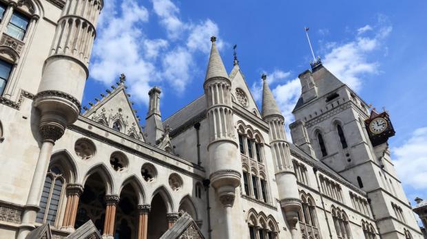 A view looking up at the Royal Courts of Justice against a bright blue sky