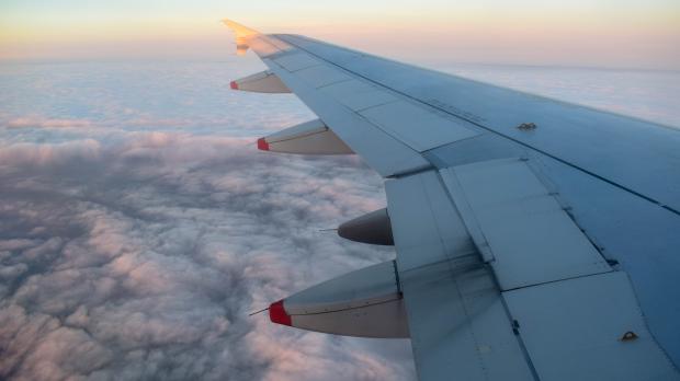 Wing of an aeroplane flying above the clouds