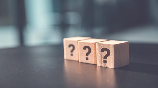 Three wooden blocks with question marks on them.