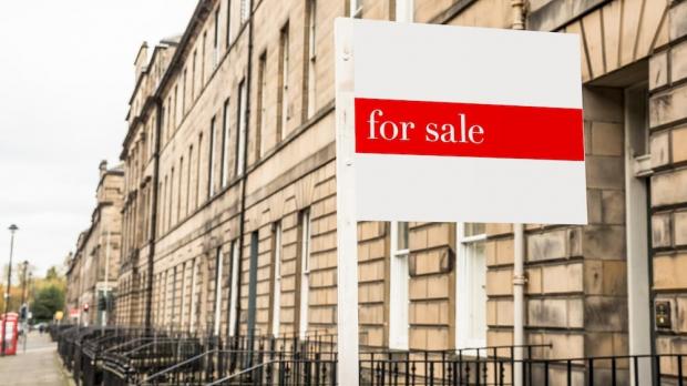 For Sale sign in front of terraced houses
