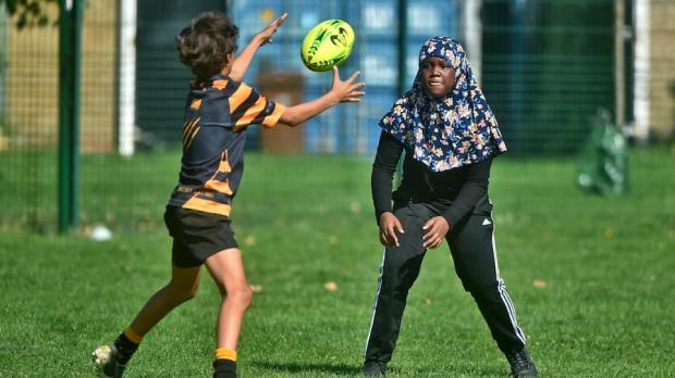 Girl in hijab playing rugby