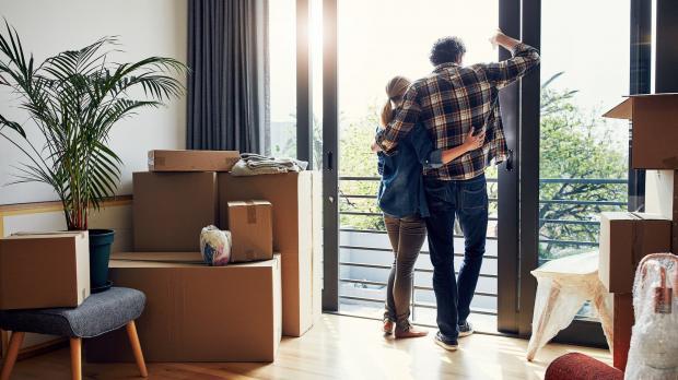 Couple looking out of the window surrounded by packing boxes