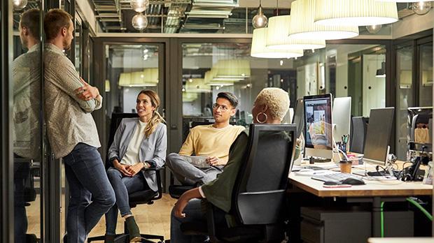 A group of people in an office chatting