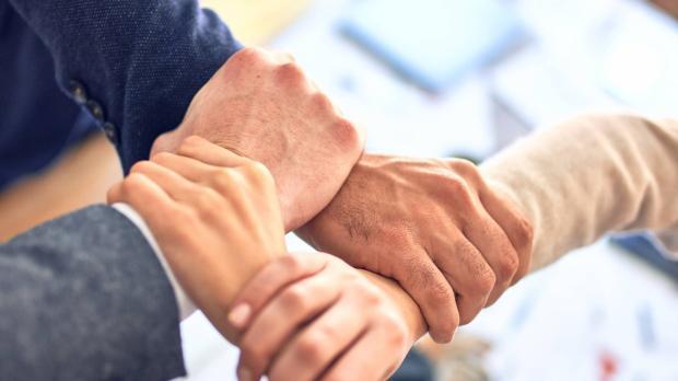 close up of 4 people joining hands together 