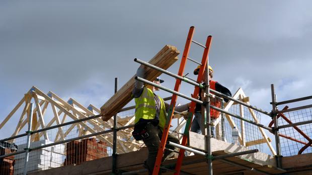 A pair of roofers working on a construction site in Manchester, England. No sharpening in camera or pp. 115939402 Construction Worker, Heavy, Residential Building, Building Exterior, 