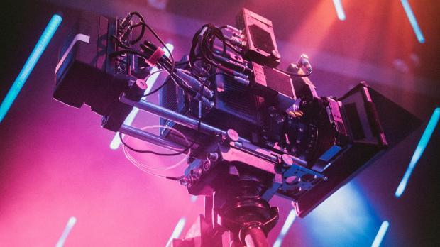 stylised shot of film camera with pink and orange lighting behind