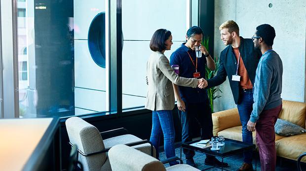 group of business people shaking hands against an office backdrop
